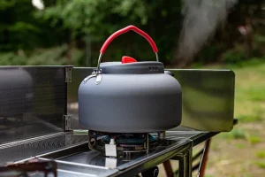 compact gas burner and kettle inside the Dare to be Different chuckbox M kitchen setup.