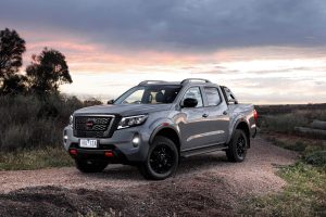 White Nissan Navara driving off-road at sunset