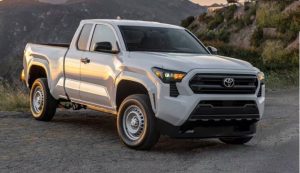 White Toyota Tacoma parked on a dirt road with off-road tires.